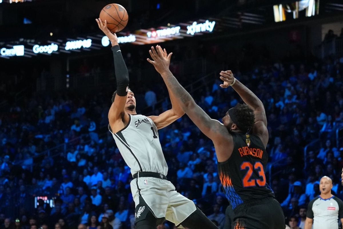 Dec 16, 2025; Las Vegas, Nevada, USA; San Antonio Spurs forward Victor Wembanyama (1) shoots the ball over New York Knicks center Mitchell Robinson (23) during the Emirates NBA Cup Final at T-Mobile Arena. Mandatory Credit: Kirby Lee-Imagn Images