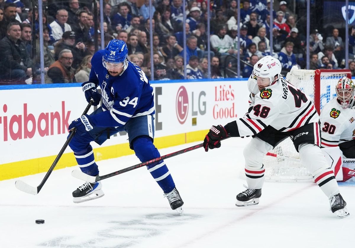Dec 16, 2025; Toronto, Ontario, CAN; Toronto Maple Leafs center Auston Matthews (34) battles for the puck with Chicago Blackhawks defenseman Matt Grzelcyk (48) during the third period at Scotiabank Arena. Mandatory Credit: Nick Turchiaro-Imagn Images
