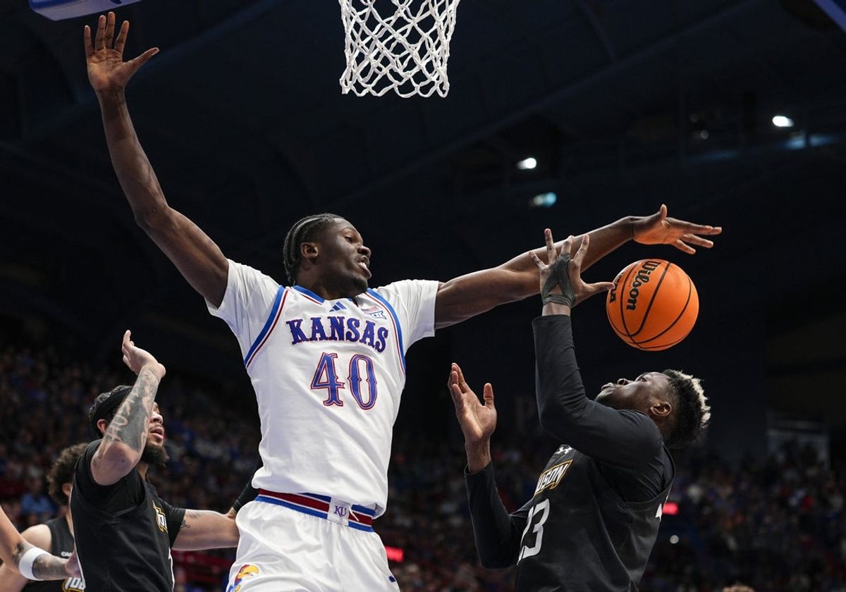 Dec 16, 2025; Lawrence, Kansas, USA; Kansas Jayhawks forward Flory Bidunga (40) and Towson Tigers forward Caleb Embeya (23) fight for a rebound during the second half at Allen Fieldhouse. Mandatory Credit: Jay Biggerstaff-Imagn Images