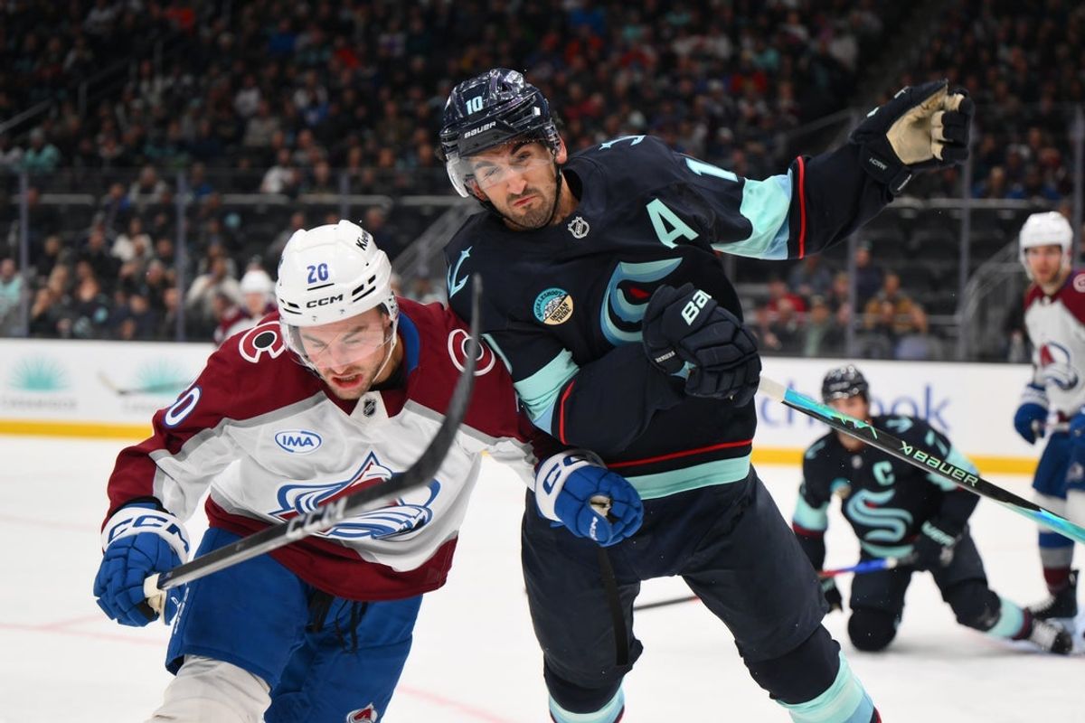 Dec 16, 2025; Seattle, Washington, USA; Colorado Avalanche center Ross Colton (20) and Seattle Kraken center Matty Beniers (10) collide while chasing the loose puck during the second period at Climate Pledge Arena. Mandatory Credit: Steven Bisig-Imagn Images