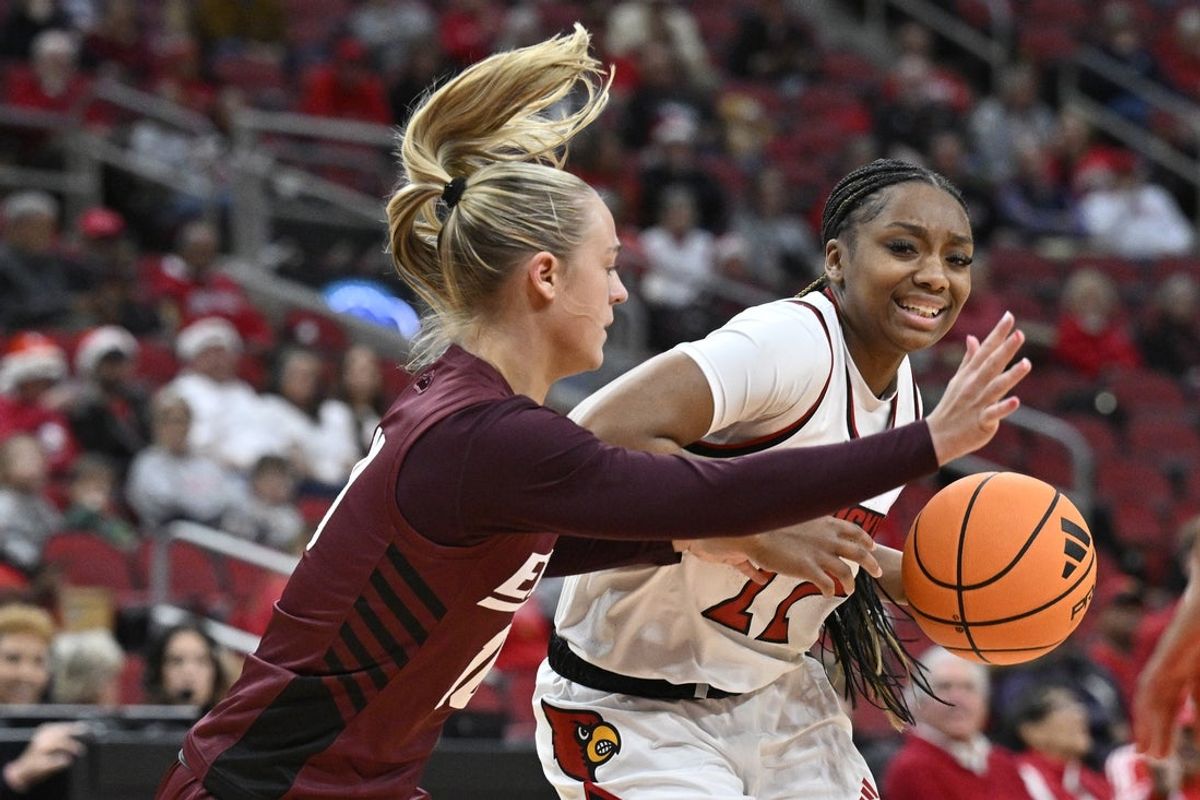 Dec 17, 2025; Louisville, Kentucky, USA;  Louisville Cardinals guard Tajianna Roberts (22) dribbles against Eastern Kentucky Colonels guard Kenleigh Woods (10) during the first half at KFC Yum! Center. Mandatory Credit: Jamie Rhodes-Imagn Images