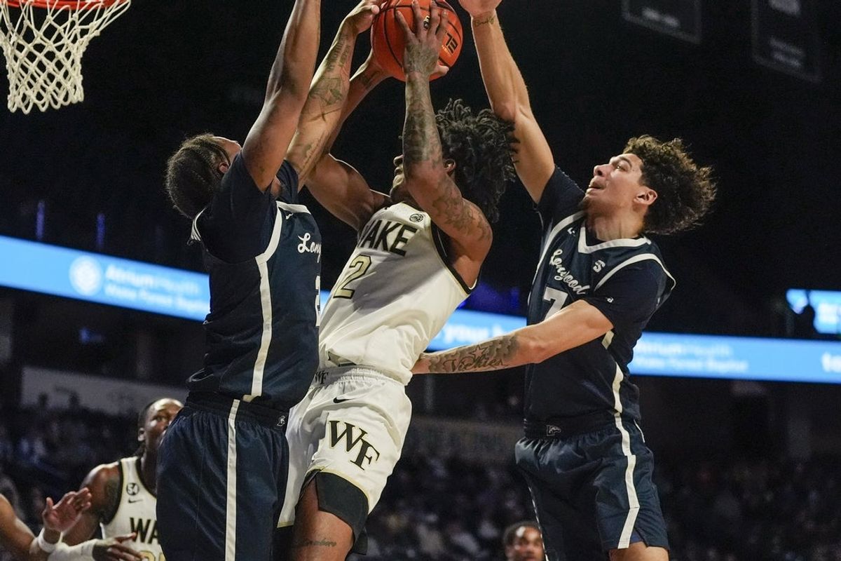 Dec 17, 2025; Winston-Salem, North Carolina, USA; Wake Forest Demon Deacons guard Juke Harris (2) goes to the basket against Longwood Lancers guard Redd Thompson Jr. (2) and guard Elijah Kelly (7) and during the first half at Lawrence Joel Veterans Memorial Coliseum. Mandatory Credit: Jim Dedmon-Imagn Images