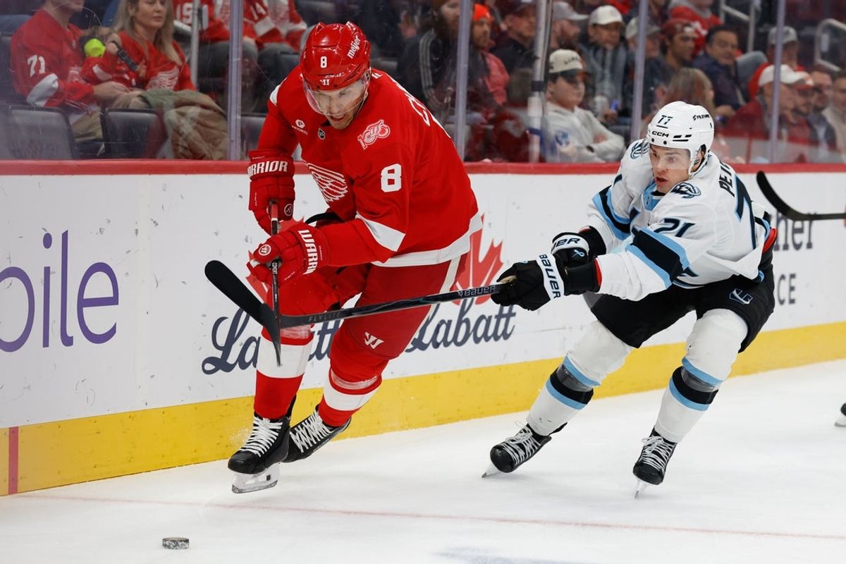 Dec 17, 2025; Detroit, Michigan, USA;  Detroit Red Wings defenseman Ben Chiarot (8) and Utah Mammoth right wing JJ Peterka (77) battle for the puck in the first period in the first period at Little Caesars Arena. Mandatory Credit: Rick Osentoski-Imagn Images