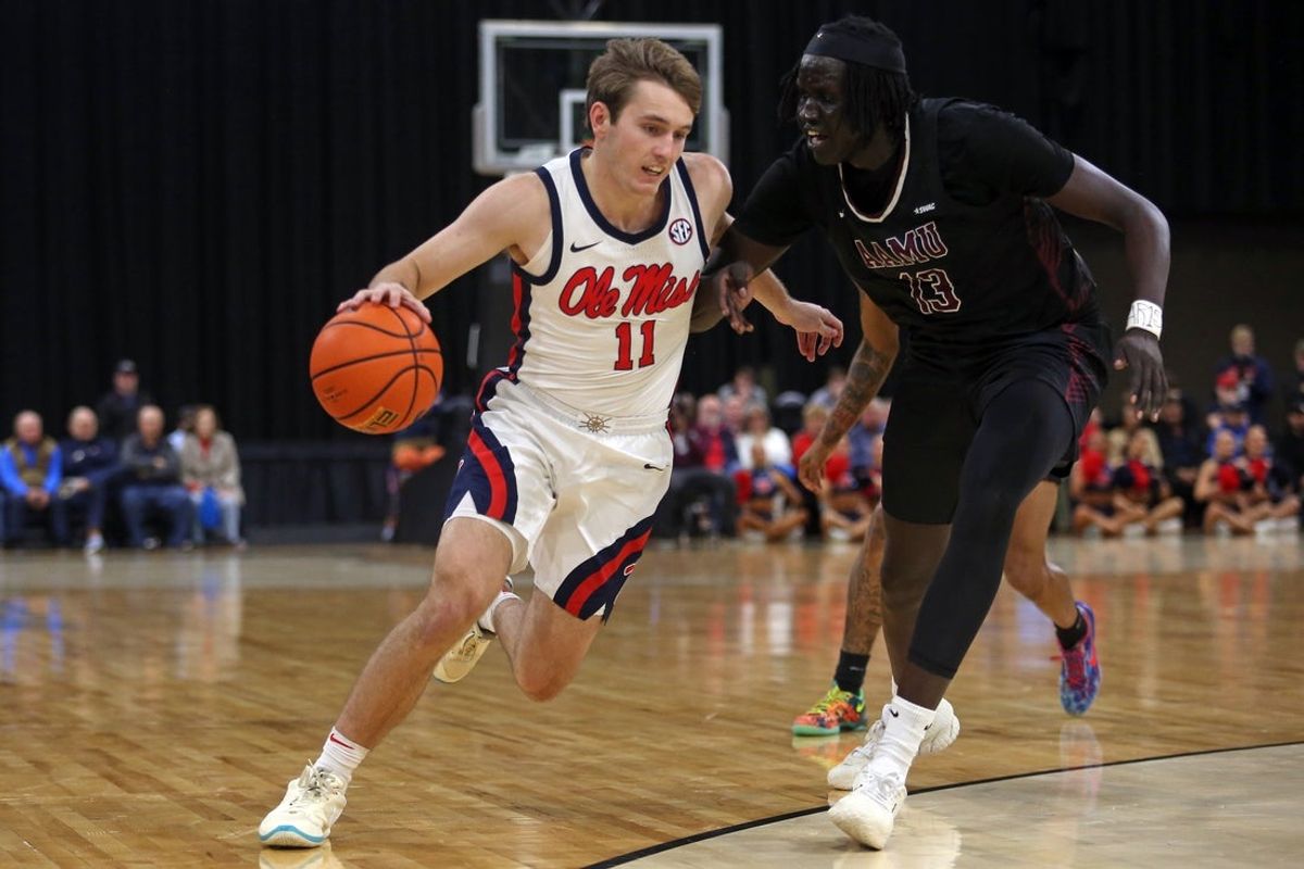 Dec 17, 2025; Tupelo, Mississippi, USA; Mississippi Rebels guard Travis Perry (11) drives to the basket as Alabama A&M Bulldogs forward Angok Anyang (13) defends during the first half at Cadence Bank Arena. Mandatory Credit: Petre Thomas-Imagn Images