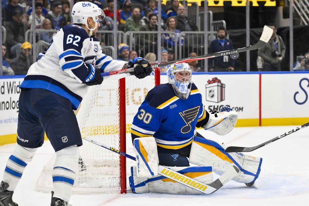 Dec 17, 2025; St. Louis, Missouri, USA; St. Louis Blues goaltender Joel Hofer (30) defends the net against Winnipeg Jets right wing Nino Niederreiter (62) during the first period at Enterprise Center. Mandatory Credit: Jeff Curry-Imagn Images
