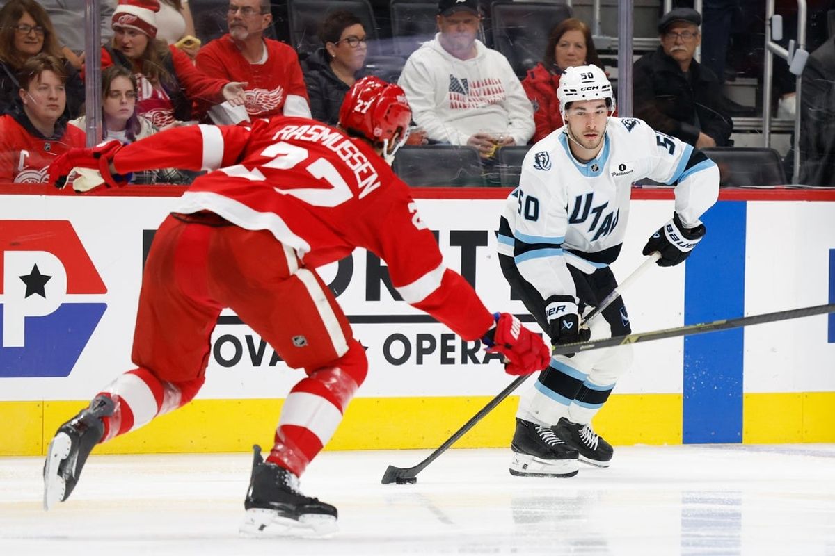 Dec 17, 2025; Detroit, Michigan, USA;  Utah Mammoth wing Sean Durzi (50) skates with the puck defended by Detroit Red Wings center Michael Rasmussen (27) in the third period at Little Caesars Arena. Mandatory Credit: Rick Osentoski-Imagn Images