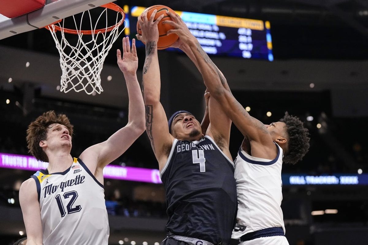 Dec 17, 2025; Milwaukee, Wisconsin, USA;  Georgetown Hoyas forward Caleb Williams (4) grabs a rebound between Marquette Golden Eagles forward Ben Gold (12) and forward Damarius Owens (9) during the second half at Fiserv Forum. Mandatory Credit: Jeff Hanisch-Imagn Images
