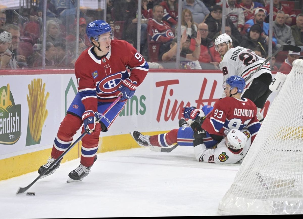 Dec 18, 2025; Montreal, Quebec, CAN; Montreal Canadiens forward Oliver Kapanen (91) plays the puck after teammate forward Ivan Demidov (93) is pulled down by Chicago Blackhawks defenseman Artyom Levshunov (55) during the first period at the Bell Centre. Mandatory Credit: Eric Bolte-Imagn Images