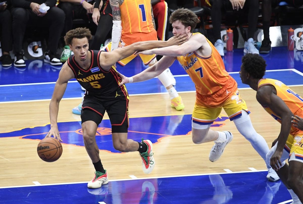 Dec 18, 2025; Charlotte, North Carolina, USA;  Atlanta Hawks guard Dyson Daniels (5) drives past Charlotte Hornets forward Koa Knueppel (7) during the first half at the Spectrum Center. Mandatory Credit: Sam Sharpe-Imagn Images