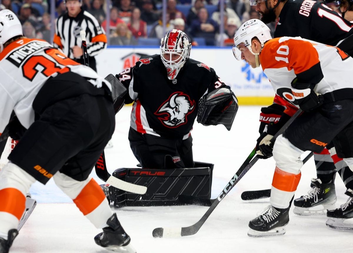 Dec 18, 2025; Buffalo, New York, USA;  Buffalo Sabres goaltender Alex Lyon (34) and Philadelphia Flyers right wing Bobby Brink (10) look for the puck during the first period at KeyBank Center. Mandatory Credit: Timothy T. Ludwig-Imagn Images