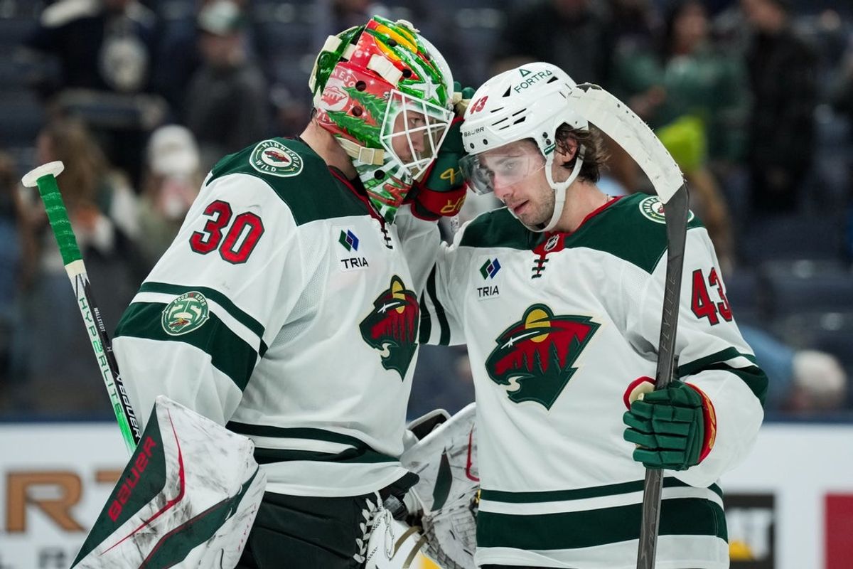 Dec 18, 2025; Columbus, Ohio, USA;  Minnesota Wild goaltender Jesper Wallstedt (30) celebrates with defenseman Quinn Hughes (43) after defeating the Columbus Blue Jackets at Nationwide Arena. Mandatory Credit: Aaron Doster-Imagn Images