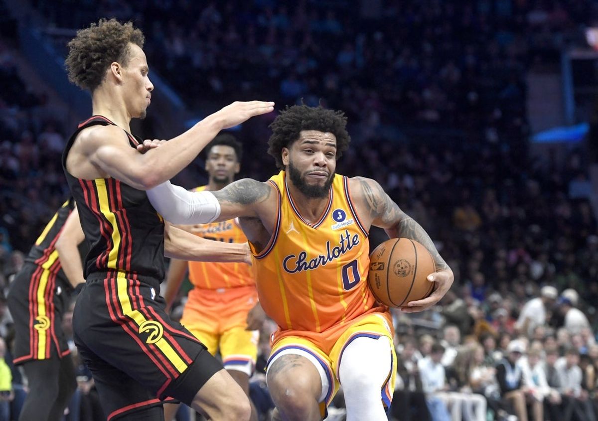 Dec 18, 2025; Charlotte, North Carolina, USA;  Charlotte Hornets forward Miles Bridges (0) drives past Atlanta Hawks guard Dyson Daniels (5) during the second half at the Spectrum Center. Mandatory Credit: Sam Sharpe-Imagn Images