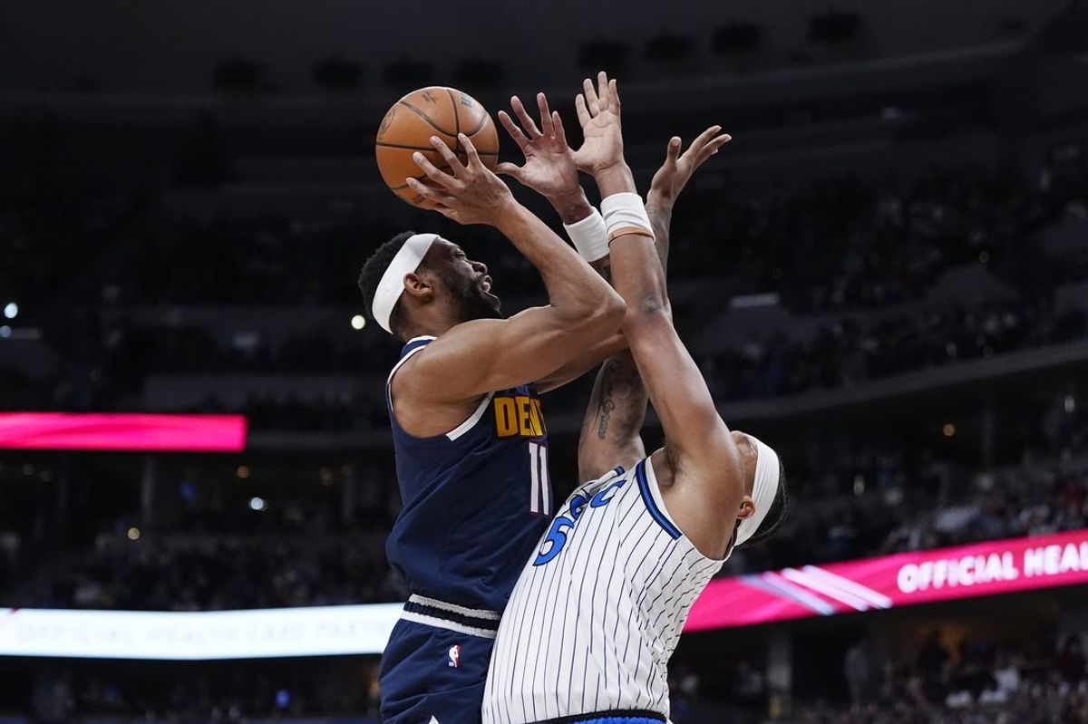 Dec 18, 2025; Denver, Colorado, USA; Denver Nuggets guard Bruce Brown (11) shoots the ball at Orlando Magic forward Paolo Banchero (5) n the second quarter at Ball Arena. Mandatory Credit: Ron Chenoy-Imagn Images