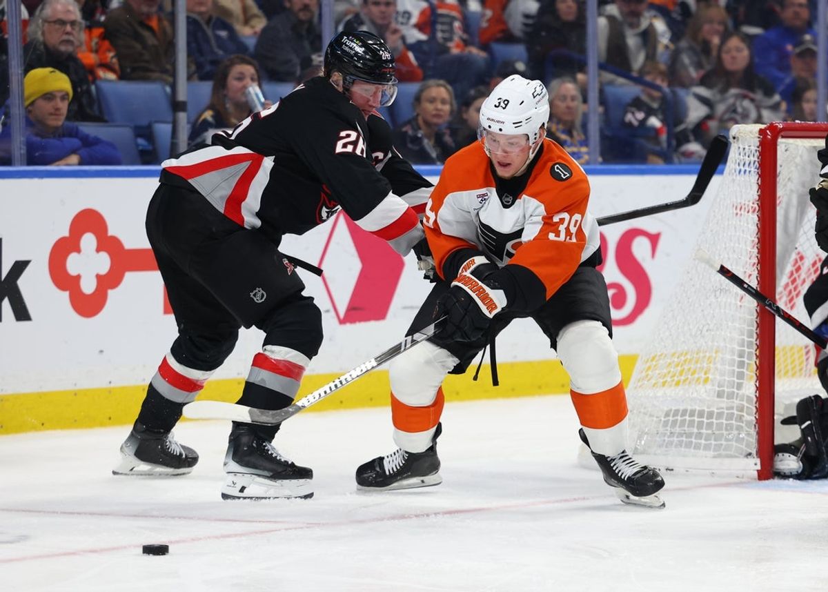 Dec 18, 2025; Buffalo, New York, USA;  Philadelphia Flyers right wing Matvei Michkov (39) tries to play the puck as Buffalo Sabres defenseman Rasmus Dahlin (26) defends during the third period at KeyBank Center. Mandatory Credit: Timothy T. Ludwig-Imagn Images