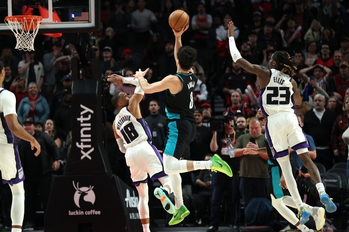 Dec 18, 2025; Portland, Oregon, USA;  Sacramento Kings guard Russell Westbrook (18) fouls Portland Trail Blazers forward Deni Avdija (8) in the closing seconds of overtime at Moda Center. Mandatory Credit: Jaime Valdez-Imagn Images