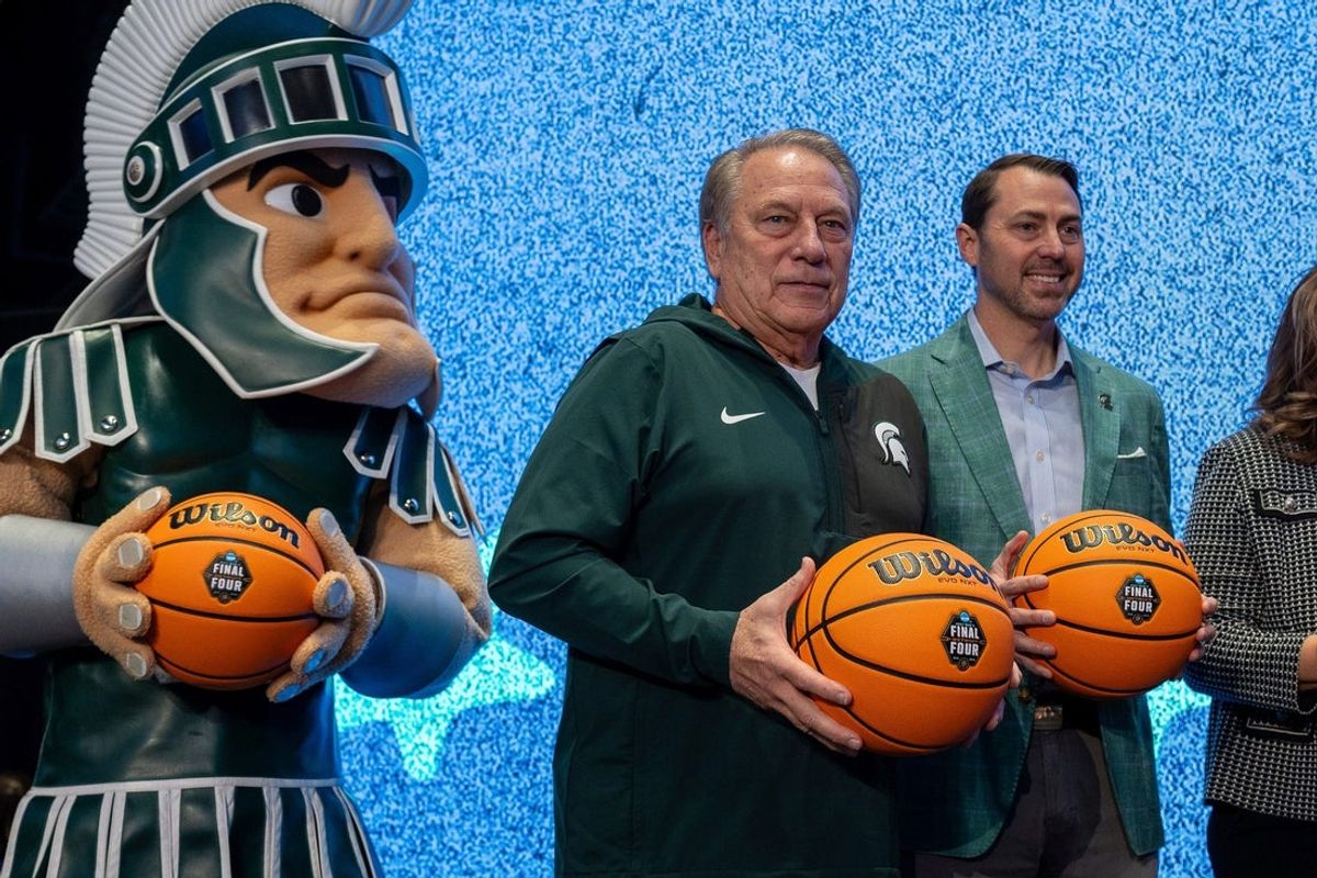 Michigan State University mascot Sparty stands on stage next to Tom Izzo, head coach of the Michigan State University men’s basketball team, and J Batt, vice president and director of athletics at Michigan State University, during a logo reveal event for the 2027 NCAA Men’s Final Four inside Ford Field in Detroit on Friday, Dec. 19, 2025.