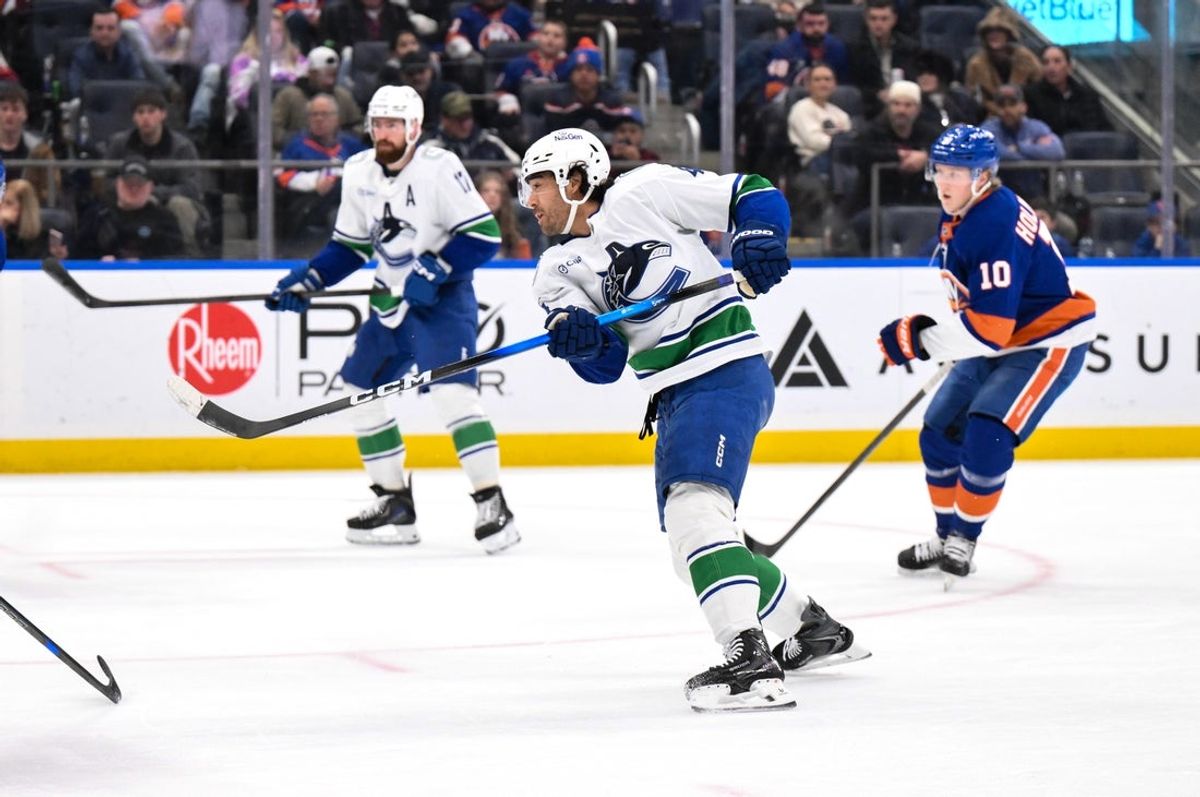Dec 19, 2025; Elmont, New York, USA; Vancouver Canucks left wing Kiefer Sherwood (44) follows through on a shot and goal against the New York Islanders during the first period at UBS Arena. Mandatory Credit: John Jones-Imagn Images