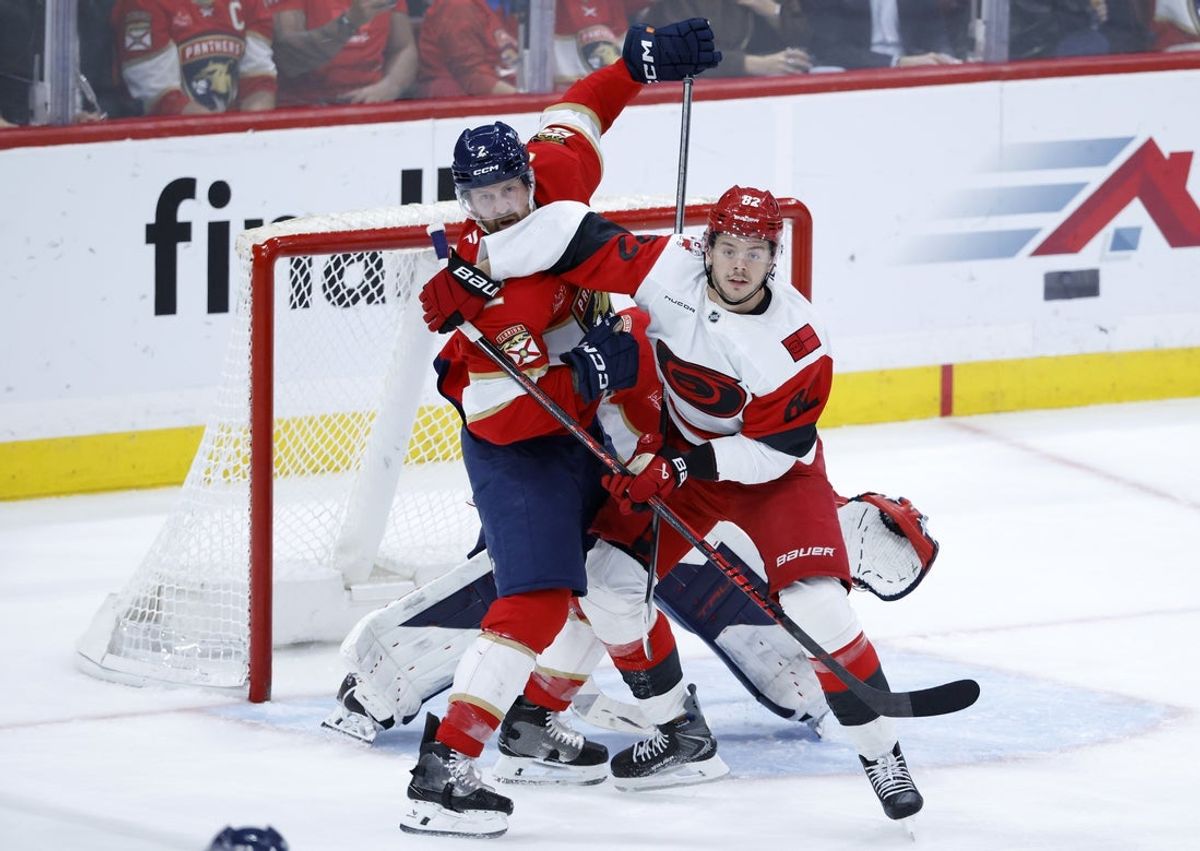 Dec 19, 2025; Sunrise, Florida, USA;  Florida Panthers defenseman Jeff Petry (2) and Carolina Hurricanes center Jesperi Kotkaniemi (82) fight for position in front of the net during the second period at Amerant Bank Arena. Mandatory Credit: Rhona Wise-Imagn Images