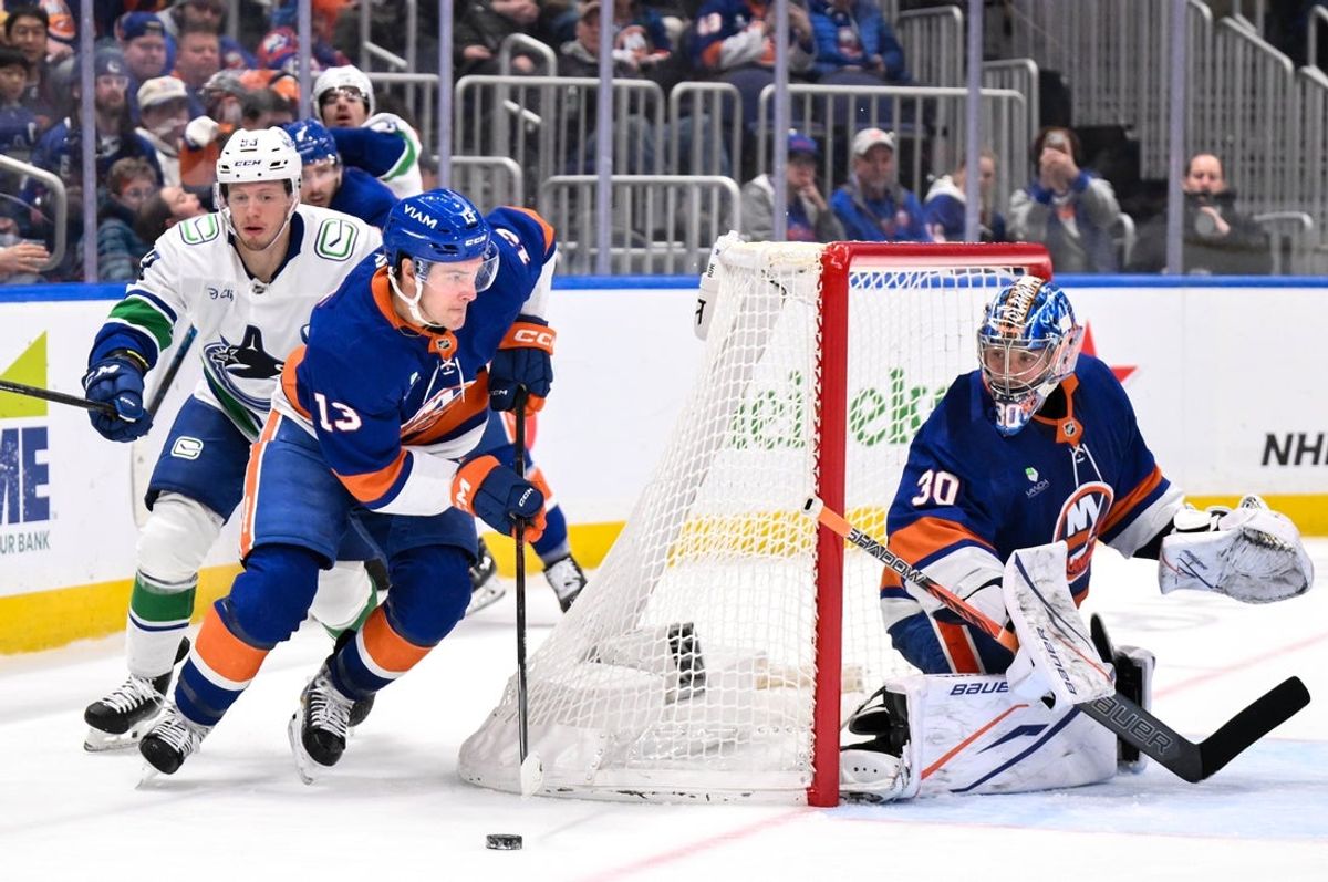 Dec 19, 2025; Elmont, New York, USA; New York Islanders center Mathew Barzal (13) skates with the puck while defended by Vancouver Canucks center Marco Rossi (93) during the third period at UBS Arena. Mandatory Credit: John Jones-Imagn Images