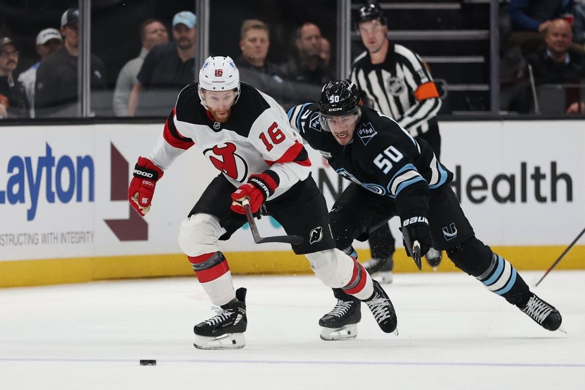 Dec 19, 2025; Salt Lake City, Utah, USA; New Jersey Devils right wing Connor Brown (16) and Utah Mammoth defenseman Sean Durzi (50) skate for the puck during the first period at Delta Center. Mandatory Credit: Rob Gray-Imagn Images