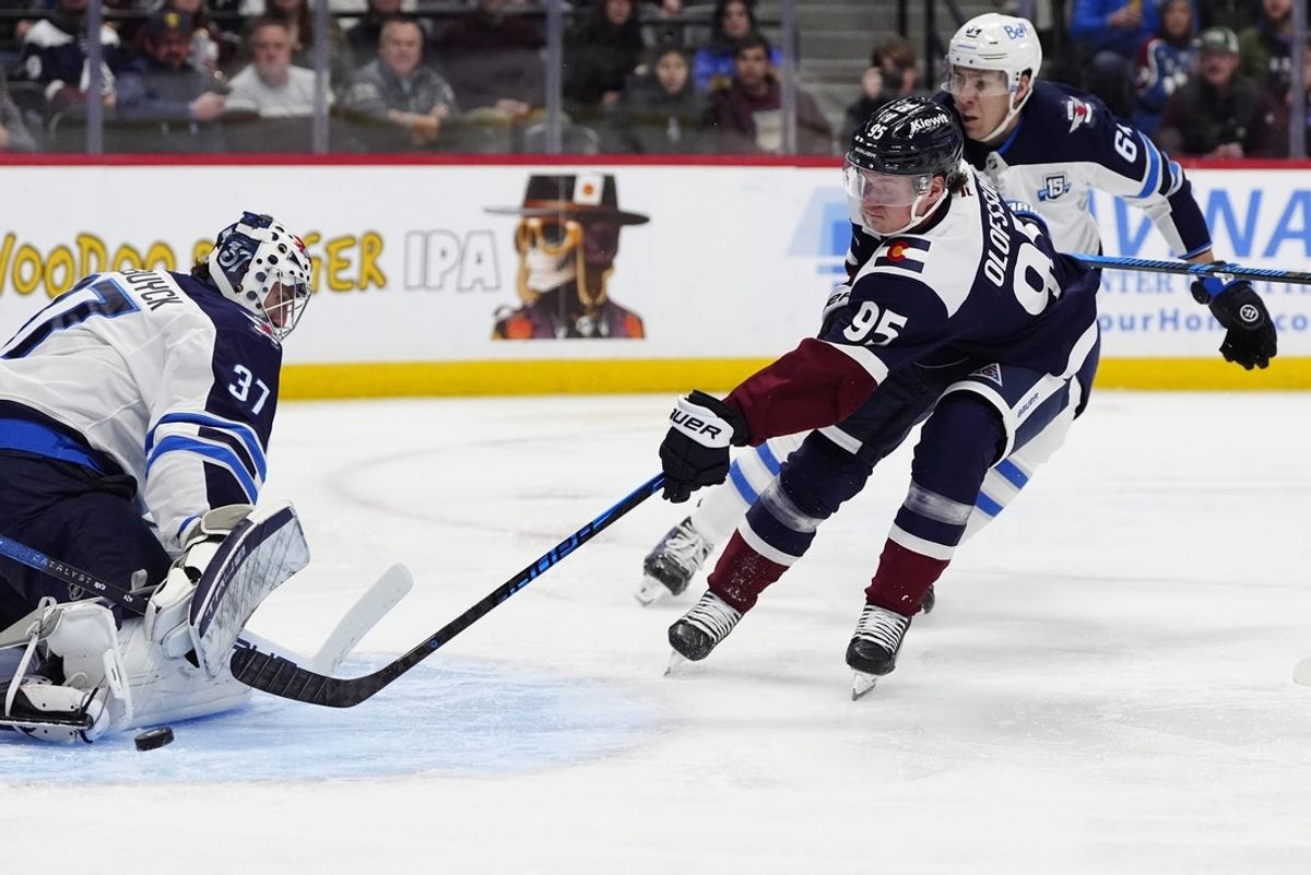 Dec 19, 2025; Denver, Colorado, USA; Winnipeg Jets goaltender Connor Hellebuyck (37) makes a save on Colorado Avalanche left wing Victor Olofsson (95) in the second period at Ball Arena. Mandatory Credit: Ron Chenoy-Imagn Images