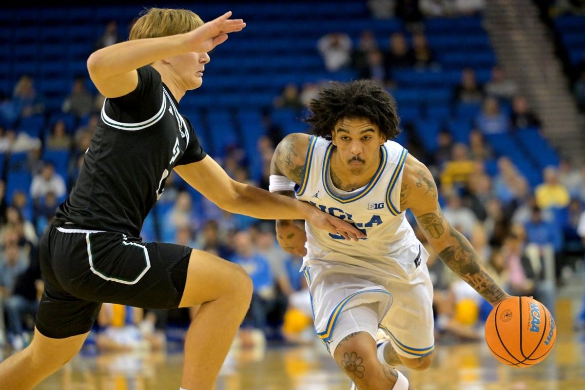 Dec 19, 2025; Los Angeles, California, USA; UCLA Bruins guard Skyy Clark (55) is defended by Cal Poly Mustangs forward Troy Plumtree (13) as he drives to the basket during the first half at Pauley Pavilion presented by Wescom Financial. Mandatory Credit: Jayne Kamin-Oncea-Imagn Images