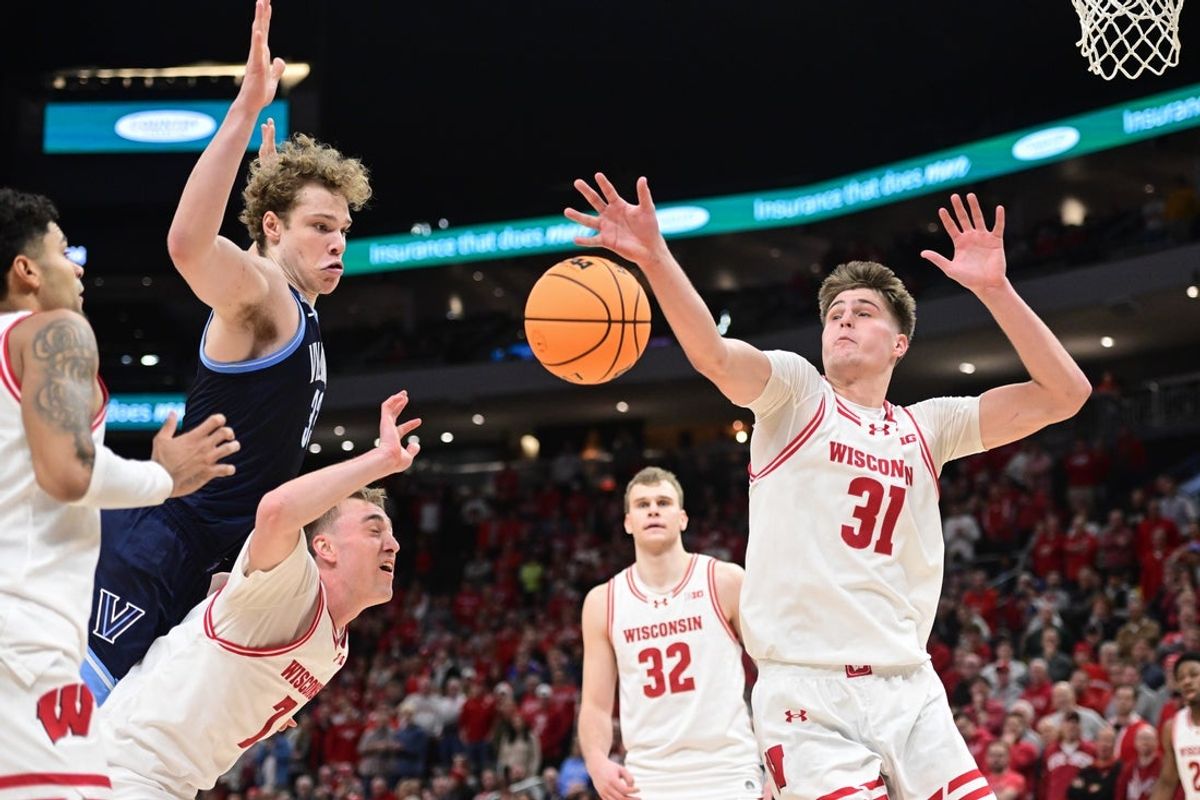 Dec 19, 2025; Milwaukee, Wisconsin, USA; Wisconsin Badgers forward Nolan Winter (31) reaches for a rebound against Villanova Wildcats forward Matt Hodge (33) in the second half at the Fiserv Forum. Mandatory Credit: Benny Sieu-Imagn Images
