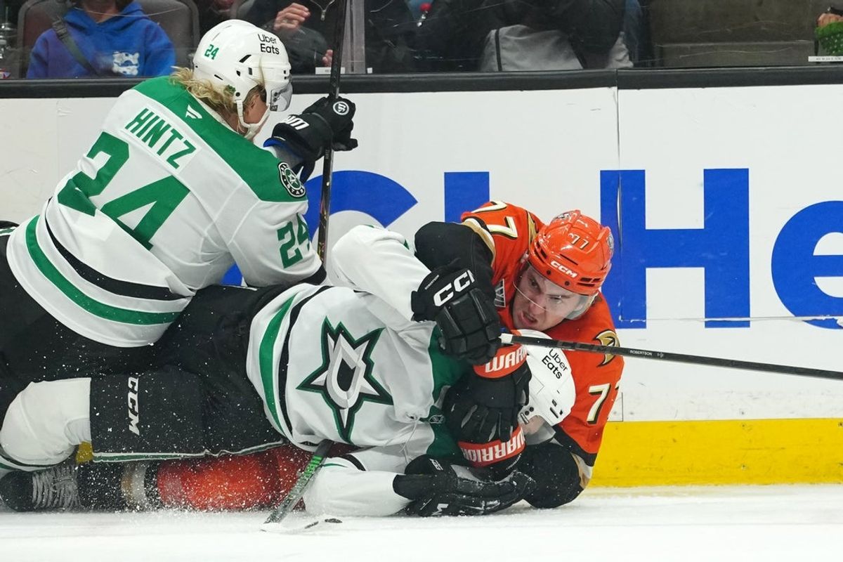 Dec 19, 2025; Anaheim, California, USA; Anaheim Ducks right wing Frank Vatrano (77) grapples with Dallas Stars left wing Jason Robertson (21) and center Roope Hintz (24) in the third period at Honda Center. Mandatory Credit: Kirby Lee-Imagn Images