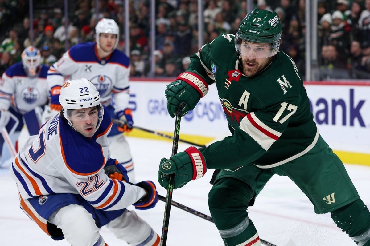 Dec 20, 2025; Saint Paul, Minnesota, USA; Minnesota Wild left wing Marcus Foligno (17) and Edmonton Oilers center Matt Savoie (22) compete for the puck during the second period at Grand Casino Arena. Mandatory Credit: Matt Krohn-Imagn Images