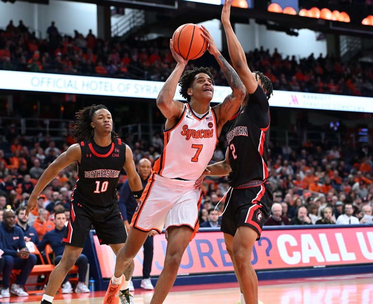 Dec 20, 2025; Syracuse, New York, USA; Syracuse Orange forward Kiyan Anthony (7) shoots the ball between Northeastern Huskies guard Ryan Williams (2) and guard Miles Newton (10) in the second half at the JMA Wireless Dome. Mandatory Credit: Mark Konezny-Imagn Images
