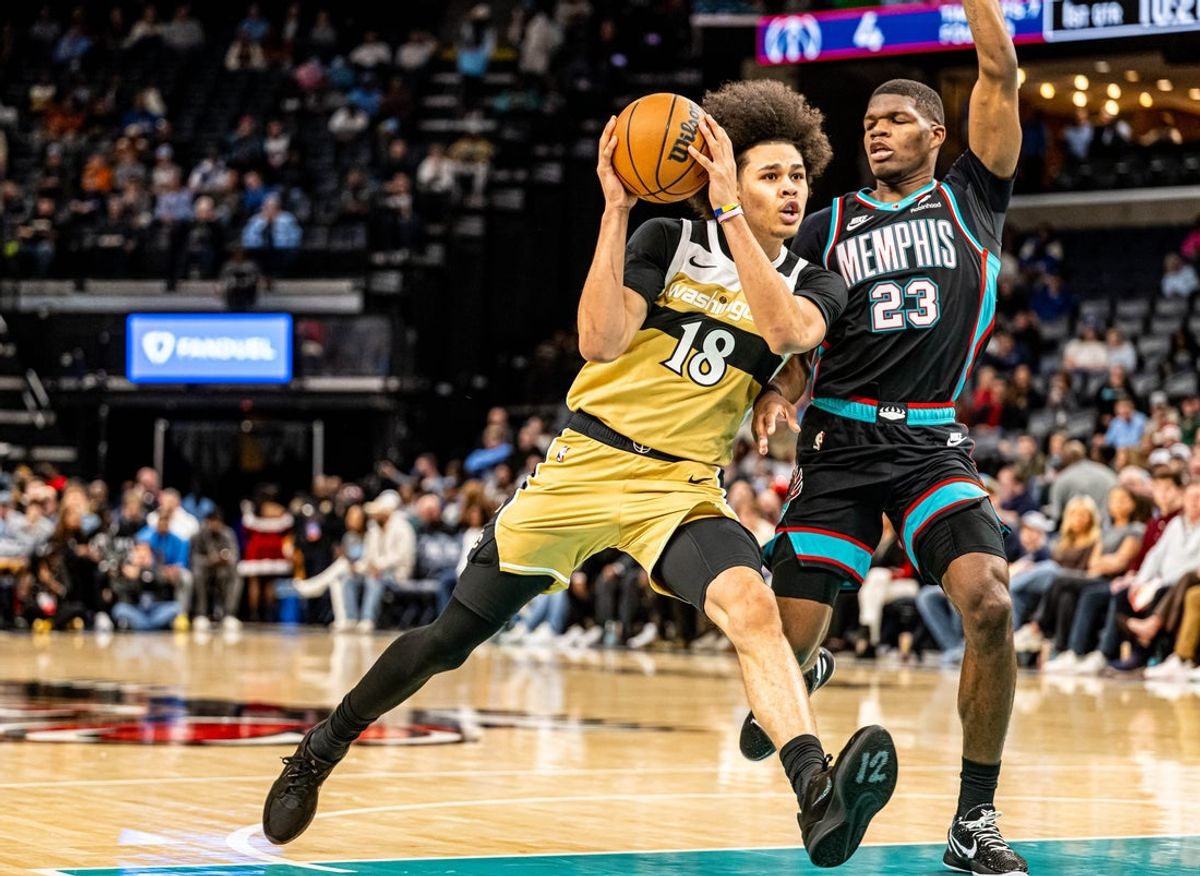 Dec 20, 2025; Memphis, Tennessee, USA; Wizards Forward Kyshawn George (18) drives into defender Memphis Grizzlies forward Cedric Coward (23) in the first quarter at FedExForum. Mandatory Credit: Matthew Smith-Imagn Images