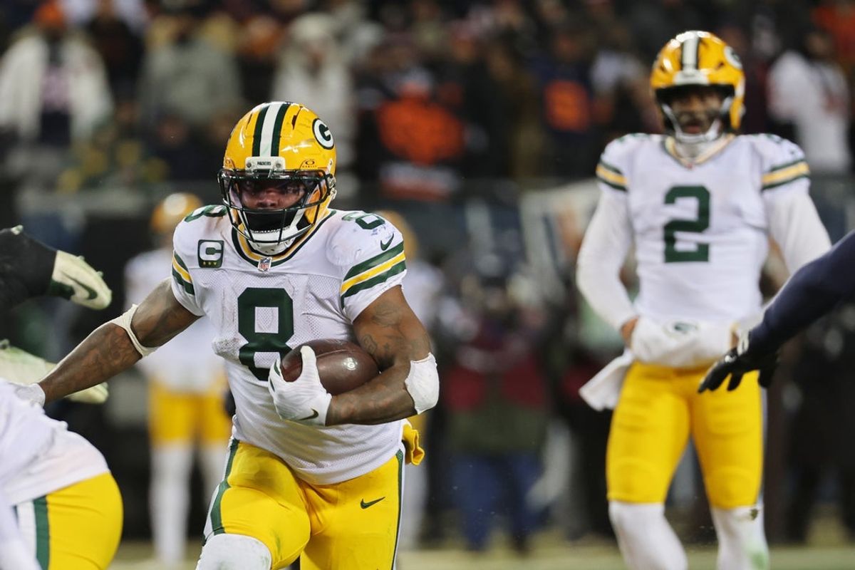 Dec 20, 2025; Chicago, Illinois, USA; Green Bay Packers running back Josh Jacobs (8) runs the ball and quarterback Malik Willis (2) watches the play against the Chicago Bears during the third quarter at Soldier Field. Mandatory Credit: Mike Dinovo-Imagn Images
