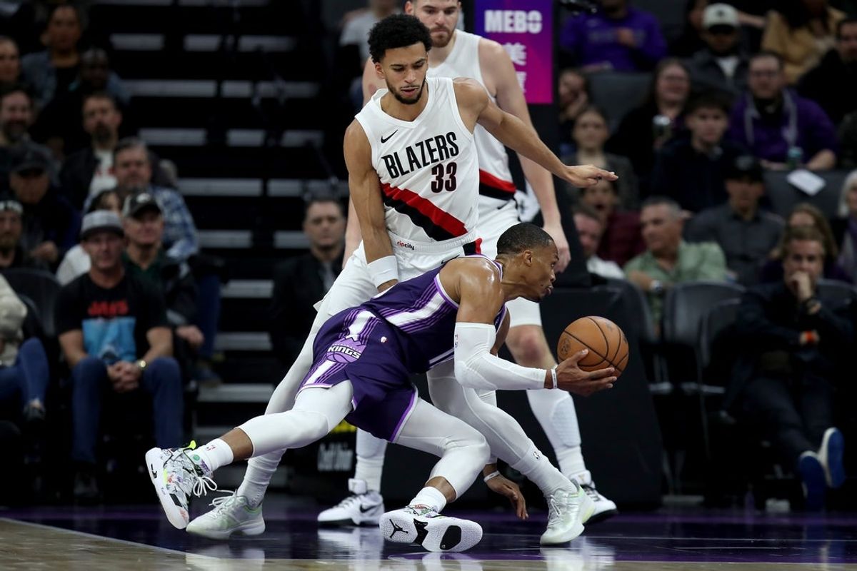 Dec 20, 2025; Sacramento, California, USA; Sacramento Kings guard Russel Westbrook (18) loses his footing while being defended by Portland Trail Blazers forward Toumani Camara (33) during the second quarter at Golden 1 Center. Mandatory Credit: Dennis Lee-Imagn Images