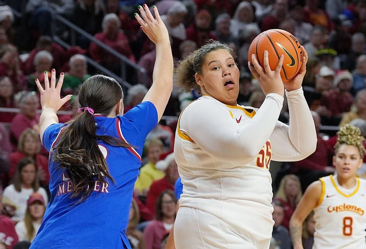 Iowa State Cyclones' center Audi Crooks (55) drives to the basket around Kansas Jayhawks forward Lilly Meister (52) during the first quarter in the Big-12 conference home opener on Dec. 21, 2025, at Hilton Coliseum in Ames, Iowa.