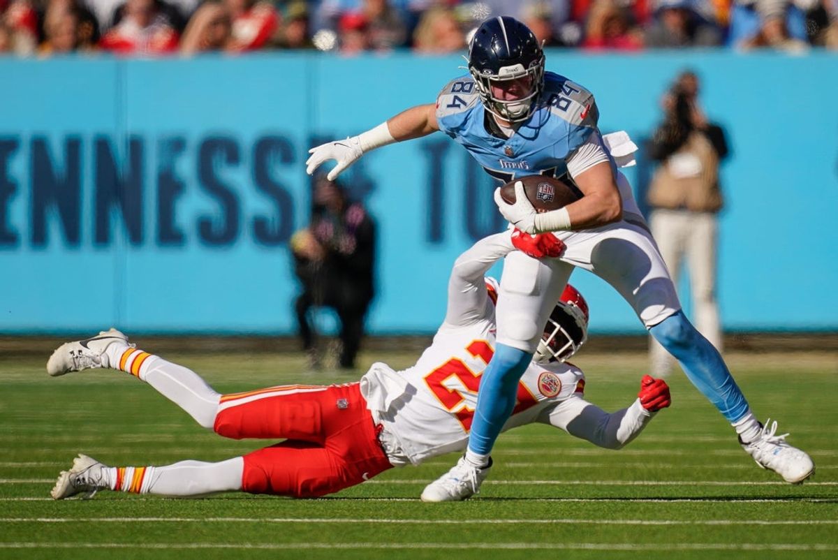 Tennessee Titans tight end Gunnar Helm (84) is tackled by Kansas City Chiefs safety Chamarri Conner (27) during the second quarter at Nissan Stadium in Nashville, Tenn., Sunday, Dec. 21, 2025.