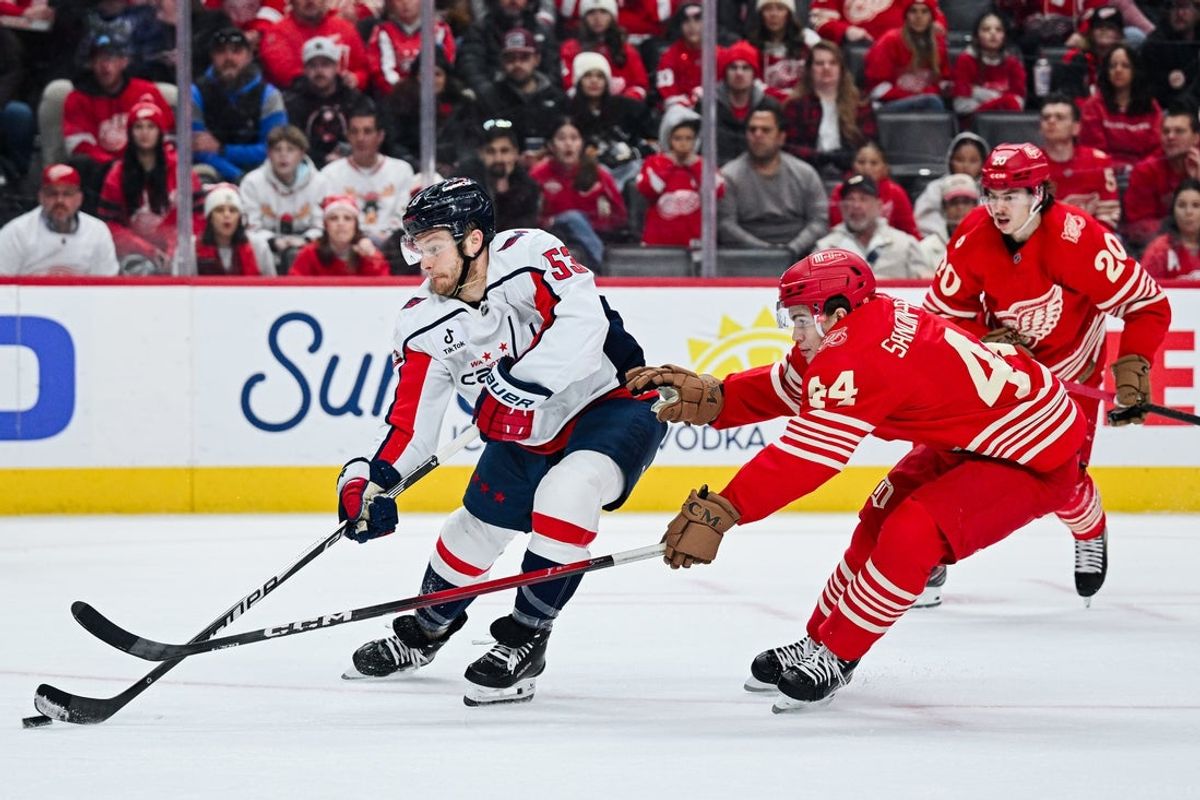 Dec 21, 2025; Detroit, Michigan, USA; Washington Capitals center Ethen Frank (53) skates past Detroit Red Wings defenseman Axel Sandin-Pellikka (44) to score a goal during the first period at Little Caesars Arena. Mandatory Credit: Tim Fuller-Imagn Images