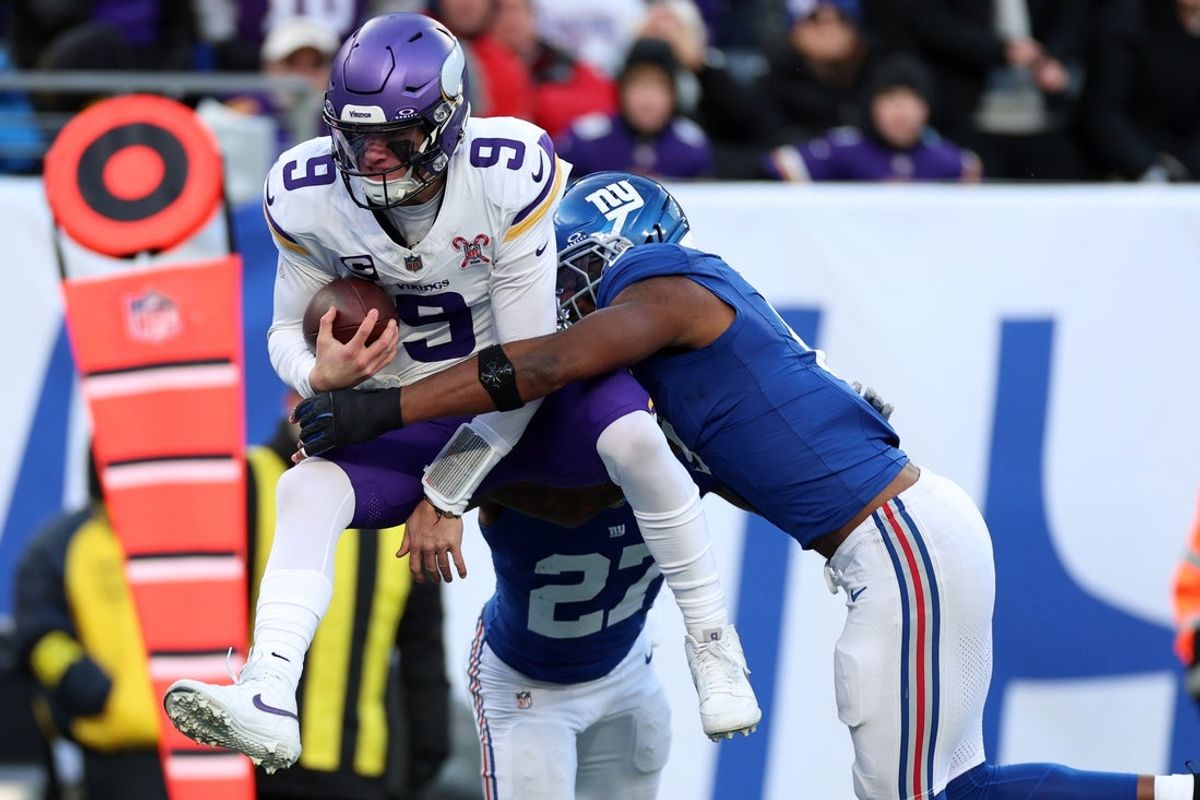 Dec 21, 2025; East Rutherford, New Jersey, USA; Minnesota Vikings quarterback J.J. McCarthy (9) leaps into the end zone against New York Giants safety Tyler Nubin (27) and linebacker Brian Burns (0)  during the first half at MetLife Stadium. Mandatory Credit: Vincent Carchietta-Imagn Images
