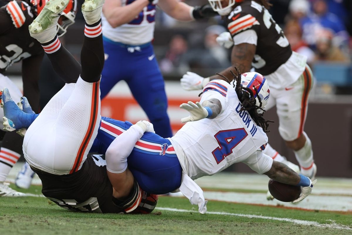 Dec 21, 2025; Cleveland, Ohio, USA;  Buffalo Bills running back James Cook III (4) scores a touchdown as Cleveland Browns linebacker Carson Schwesinger (49) defends during the first half at Huntington Bank Field. Mandatory Credit: Scott Galvin-Imagn Images