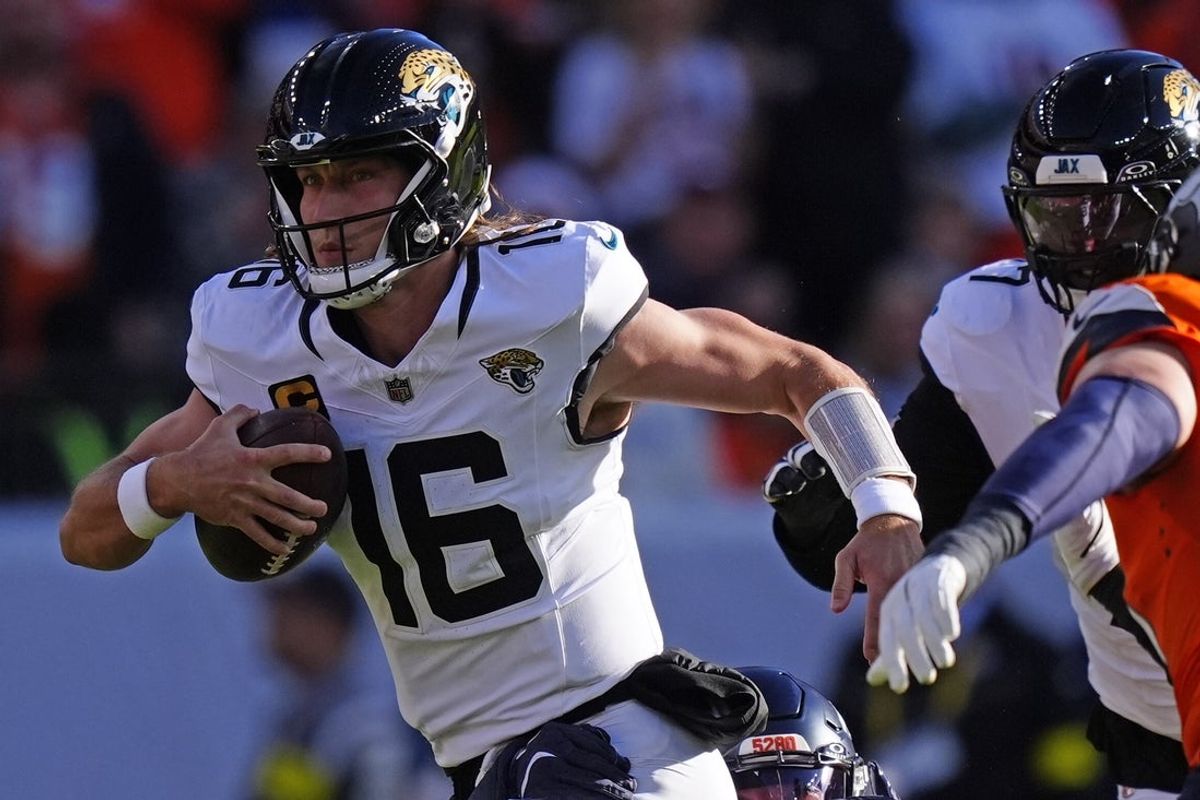 Dec 21, 2025; Denver, Colorado, USA; Jacksonville Jaguars quarterback Trevor Lawrence (16) rushes the ball against the Denver Broncos during the first half  at Empower Field at Mile High. Mandatory Credit: Ron Chenoy-Imagn Images