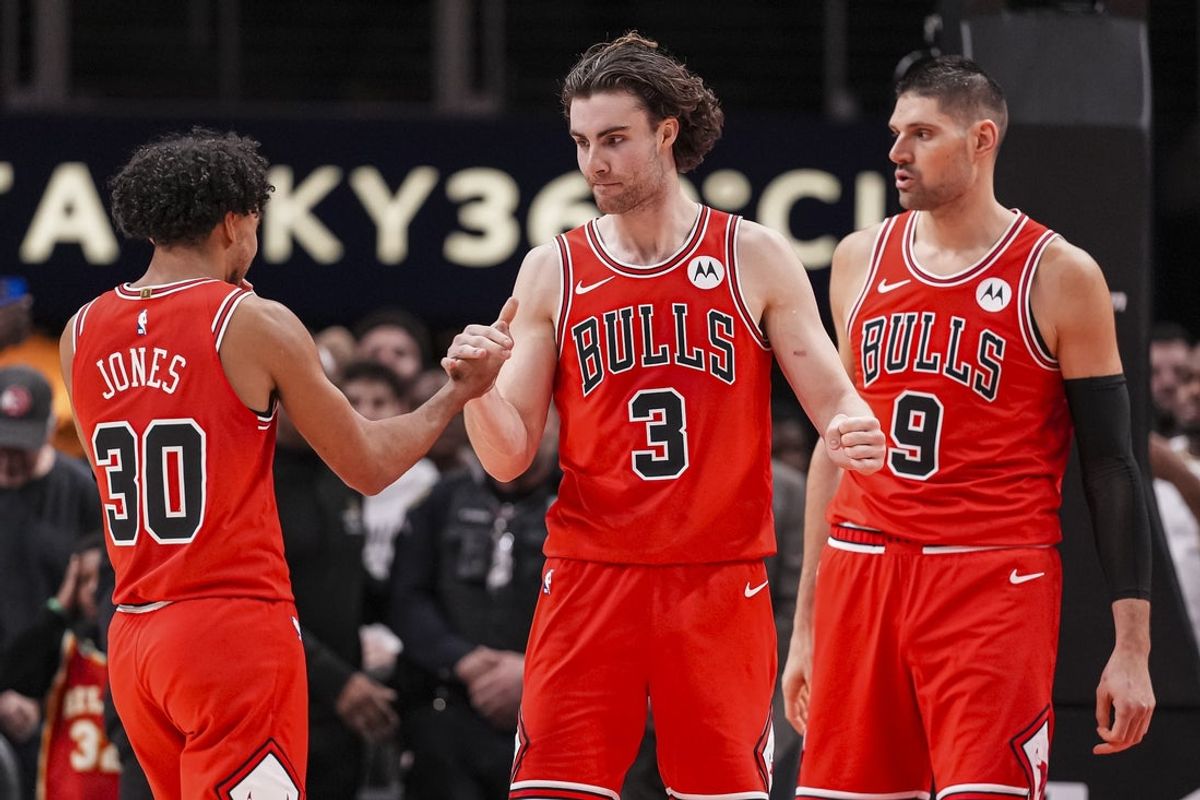 Dec 21, 2025; Atlanta, Georgia, USA; Chicago Bulls guard Tre Jones (30) guard Josh Giddey (3) and center Nikola Vucevic (9) react after defeating the Atlanta Hawks at State Farm Arena. Mandatory Credit: Dale Zanine-Imagn Images