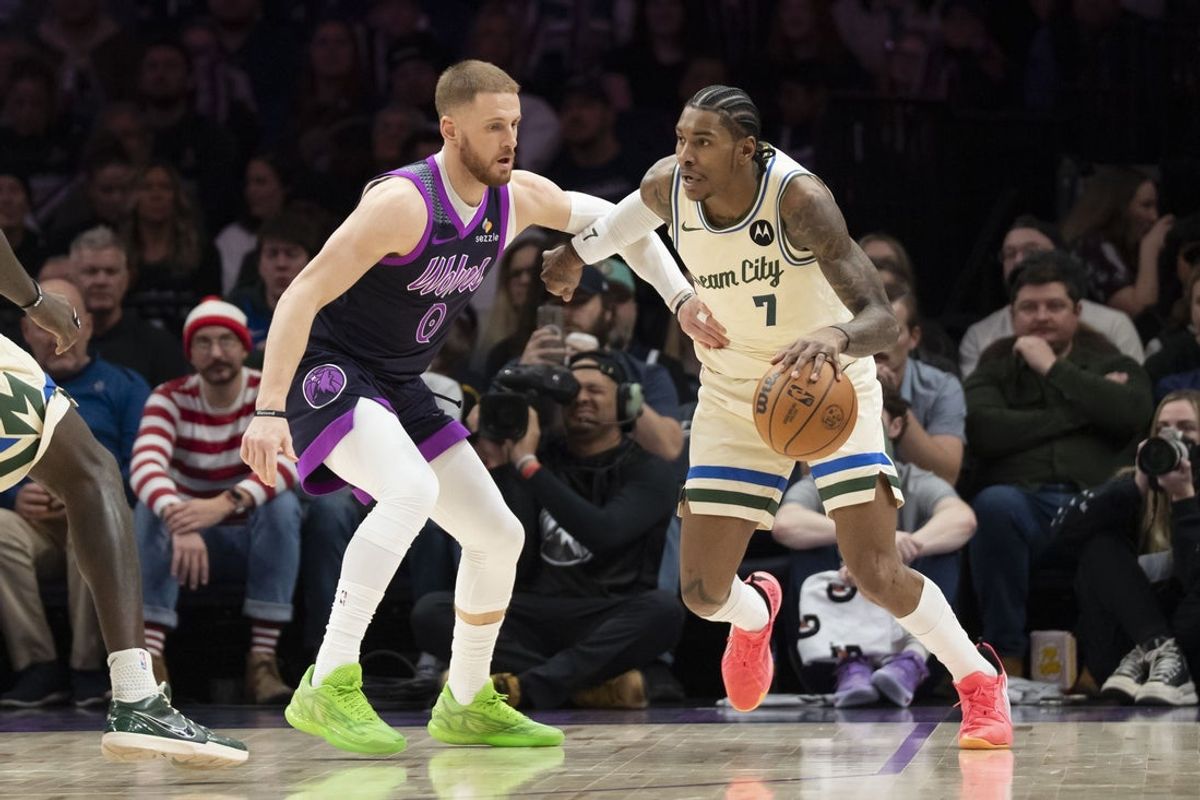 Dec 21, 2025; Minneapolis, Minnesota, USA; Milwaukee Bucks guard Kevin Porter Jr. (7) dribbles the ball as Minnesota Timberwolves guard Donte Divincenzo (0) plays defense in the second half at Target Center. Mandatory Credit: Jesse Johnson-Imagn Images