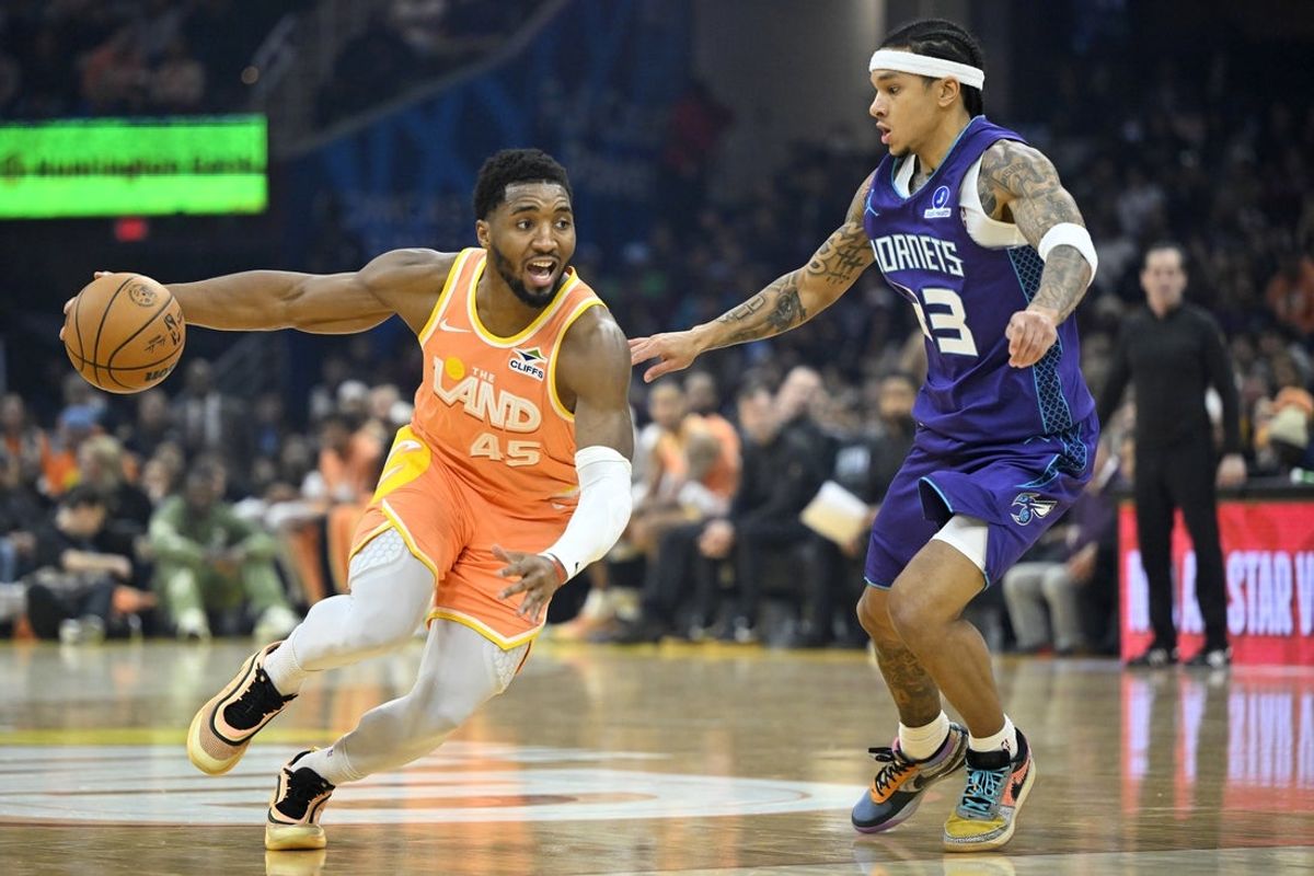 Dec 22, 2025; Cleveland, Ohio, USA; Cleveland Cavaliers guard Donovan Mitchell (45) dribbles beside Charlotte Hornets guard Tre Mann (23) in the first quarter at Rocket Arena. Mandatory Credit: David Richard-Imagn Images