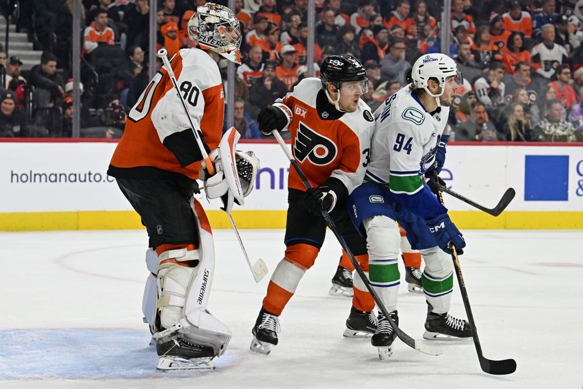 Dec 22, 2025; Philadelphia, Pennsylvania, USA;  Philadelphia Flyers defenseman Emil Andrae (36) and  Vancouver Canucks center Linus Karlsson (94) battle for position in front of goaltender Dan Vladar (80) during the first period at Xfinity Mobile Arena. Mandatory Credit: Eric Hartline-Imagn Images