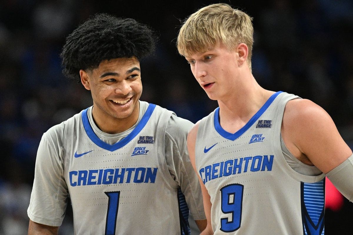 Dec 22, 2025; Omaha, Nebraska, USA;  Creighton Bluejays guard Austin Swartz (1) and guard Ty Davis (9) share a moment during a break in the game against the Utah Tech Trailblazers during the second half at CHI Health Center Omaha. Mandatory Credit: Steven Branscombe-Imagn Images
