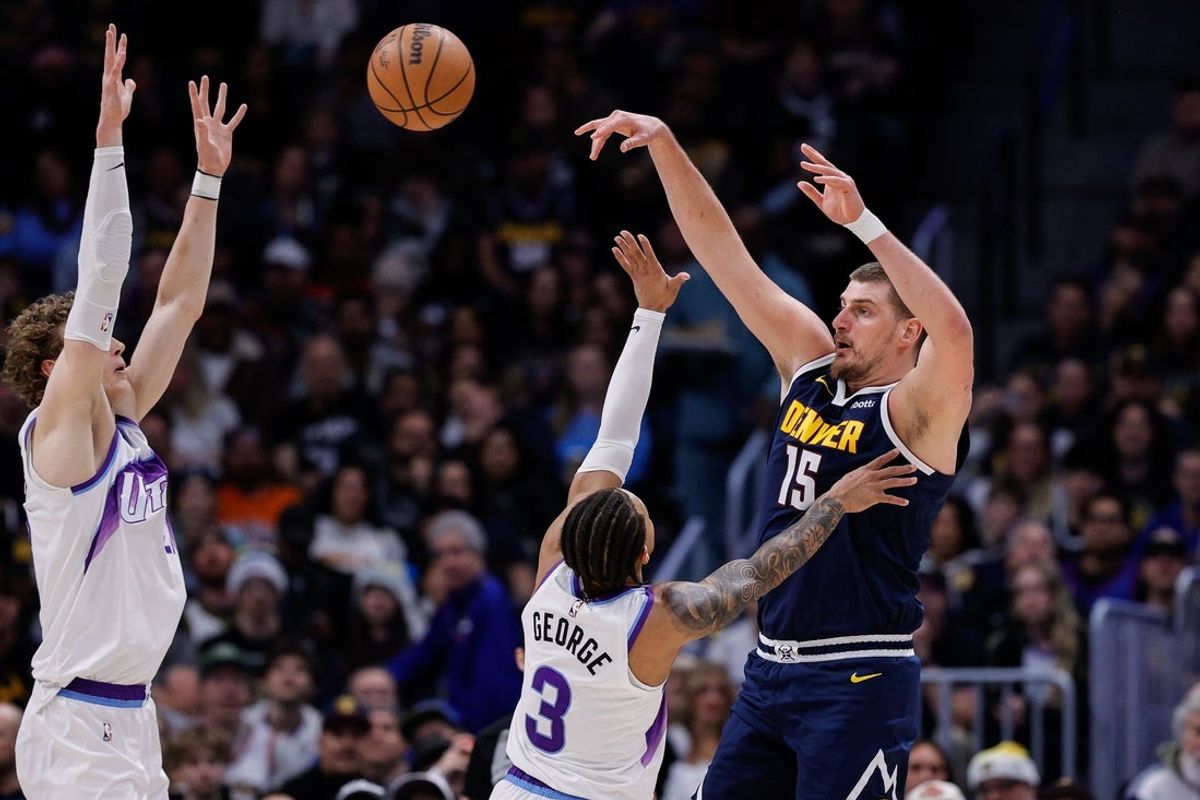 Dec 22, 2025; Denver, Colorado, USA; Denver Nuggets center Nikola Jokic (15) passes the ball as Utah Jazz guard Keyonte George (3) and forward Lauri Markkanen (23) defend in the second quarter at Ball Arena. Mandatory Credit: Isaiah J. Downing-Imagn Images