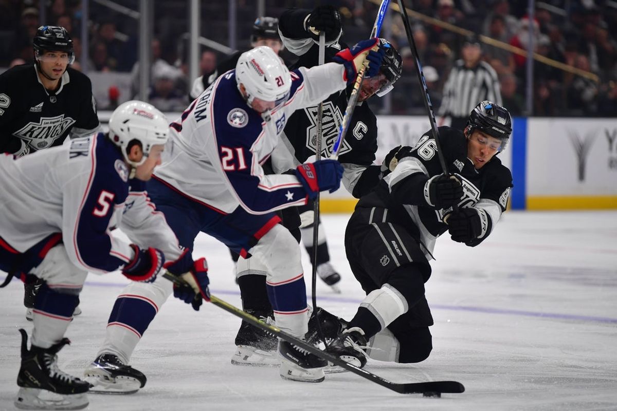 Dec 22, 2025; Los Angeles, California, USA; Los Angeles Kings center Anze Kopitar (11) and left wing Andrei Kuzmenko (96) play for the puck against Columbus Blue Jackets center Isac Lundeström (21) and defenseman Denton Mateychuk (5) during the second period at Crypto.com Arena. Mandatory Credit: Gary A. Vasquez-Imagn Images