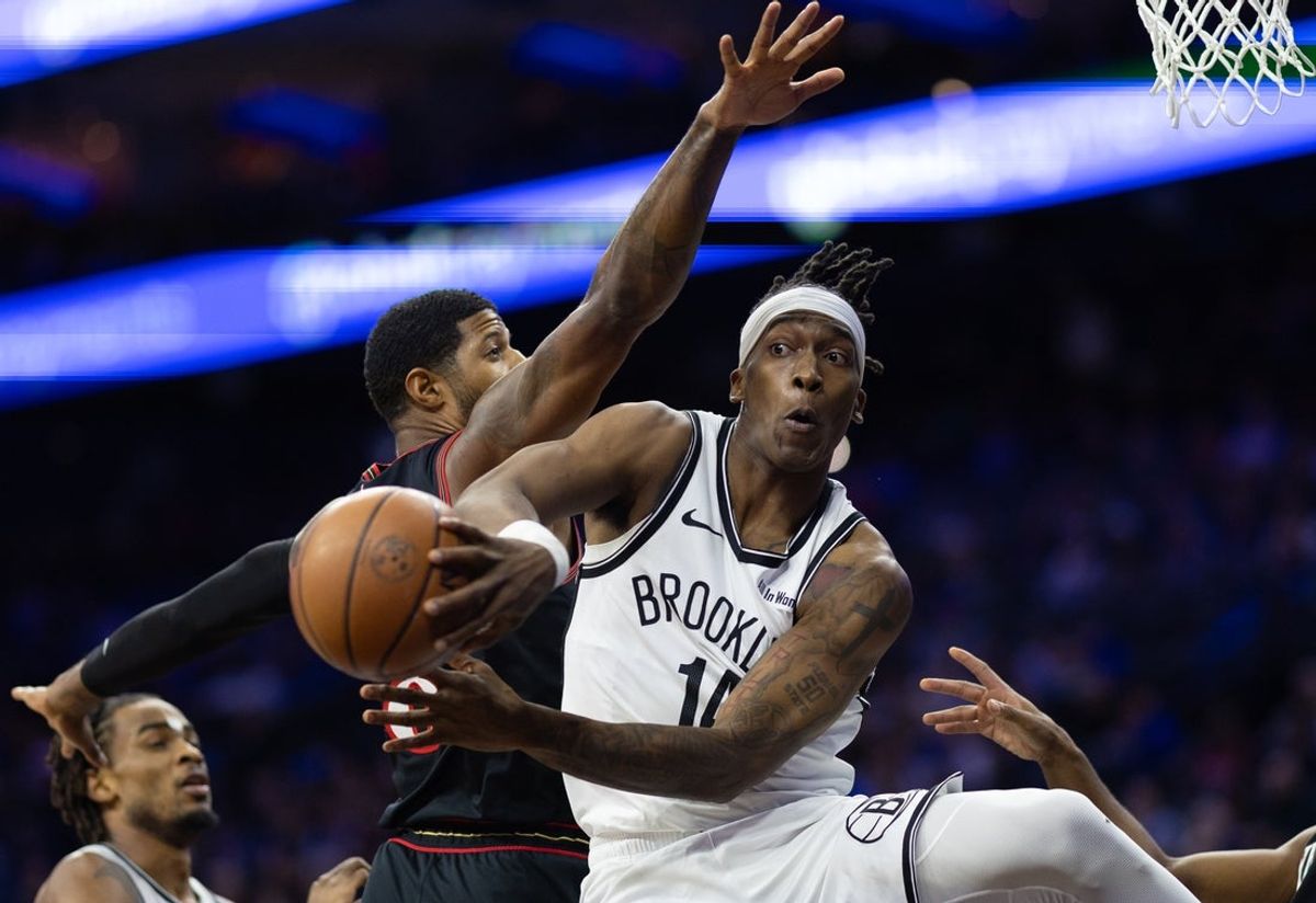Dec 23, 2025; Philadelphia, Pennsylvania, USA; Brooklyn Nets guard Terance Mann (14) passes the ball past Philadelphia 76ers forward Paul George (8) during the first quarter at Xfinity Mobile Arena. Mandatory Credit: Bill Streicher-Imagn Images