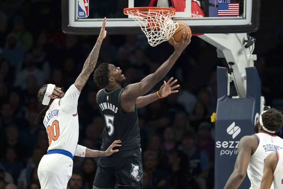 Dec 23, 2025; Minneapolis, Minnesota, USA; Minnesota Timberwolves guard Anthony Edwards (5) drives to the basket and shoots the ball past New York Knicks guard Jordan Clarkson (00) in the first half at Target Center. Mandatory Credit: Jesse Johnson-Imagn Images