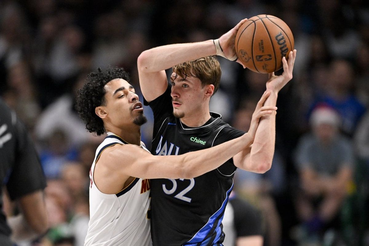 Dec 23, 2025; Dallas, Texas, USA; Dallas Mavericks forward Cooper Flagg (32) looks to pass the ball by Denver Nuggets guard Julian Strawther (3) during the second quarter at the American Airlines Center. Mandatory Credit: Jerome Miron-Imagn Images