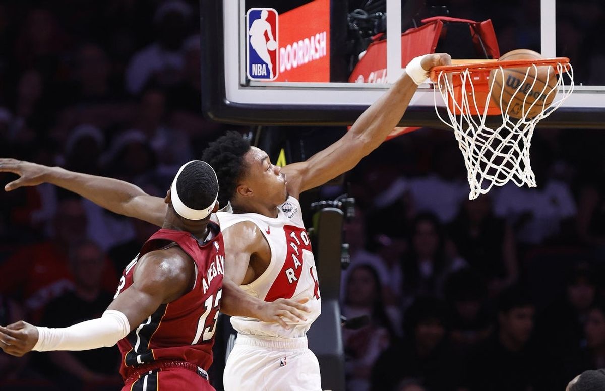 Dec 23, 2025; Miami, Florida, USA;  Toronto Raptors forward Scottie Barnes (4) dunks around Miami Heat center Bam Adebayo (13) during the second half at Kaseya Center. Mandatory Credit: Rhona Wise-Imagn Images